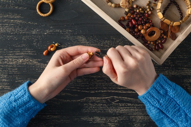 female-hands-with-colored-beads-necklace-manufacturing_155165-7296